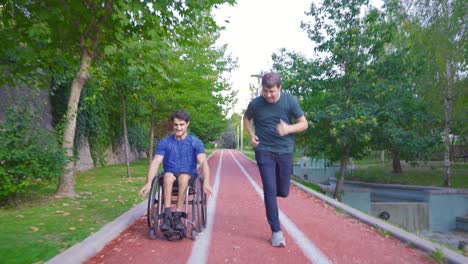 Behinderter-Teenager,-Der-Im-Rollstuhl-Sport-Treibt,-Und-Sein-Freund-Begleiten-Ihn.